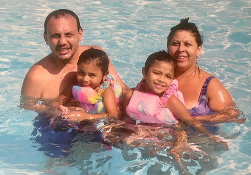 Ivanna at a young age swimming in a pool with her grandparents.