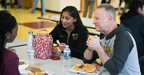 Dr. Martirano having lunch with two students.